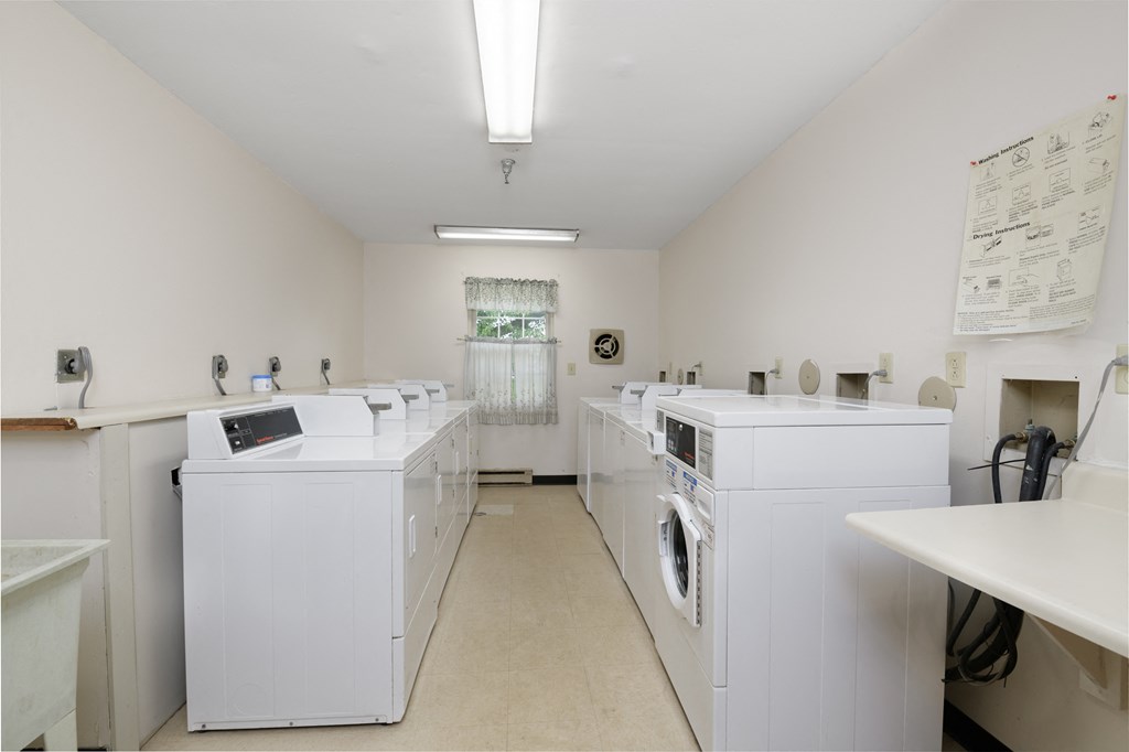 a washer and dryer room with white washes and washing machines in a