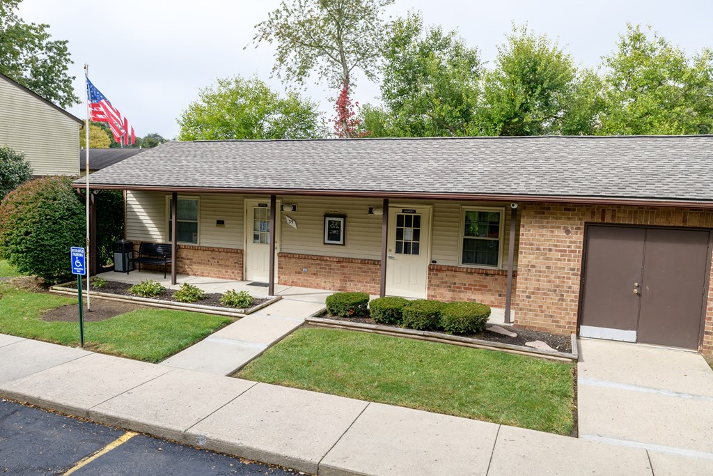 the front of a brick house with an flag