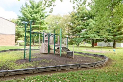 a playground with a swing set in a park