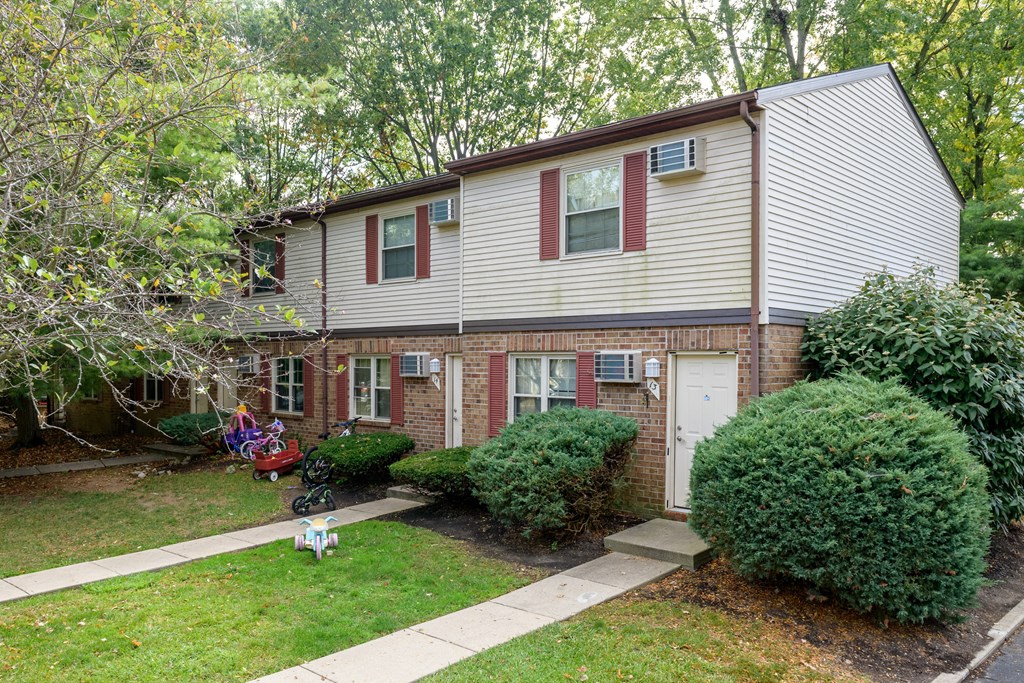 the front of a house with a yard and a white and red house