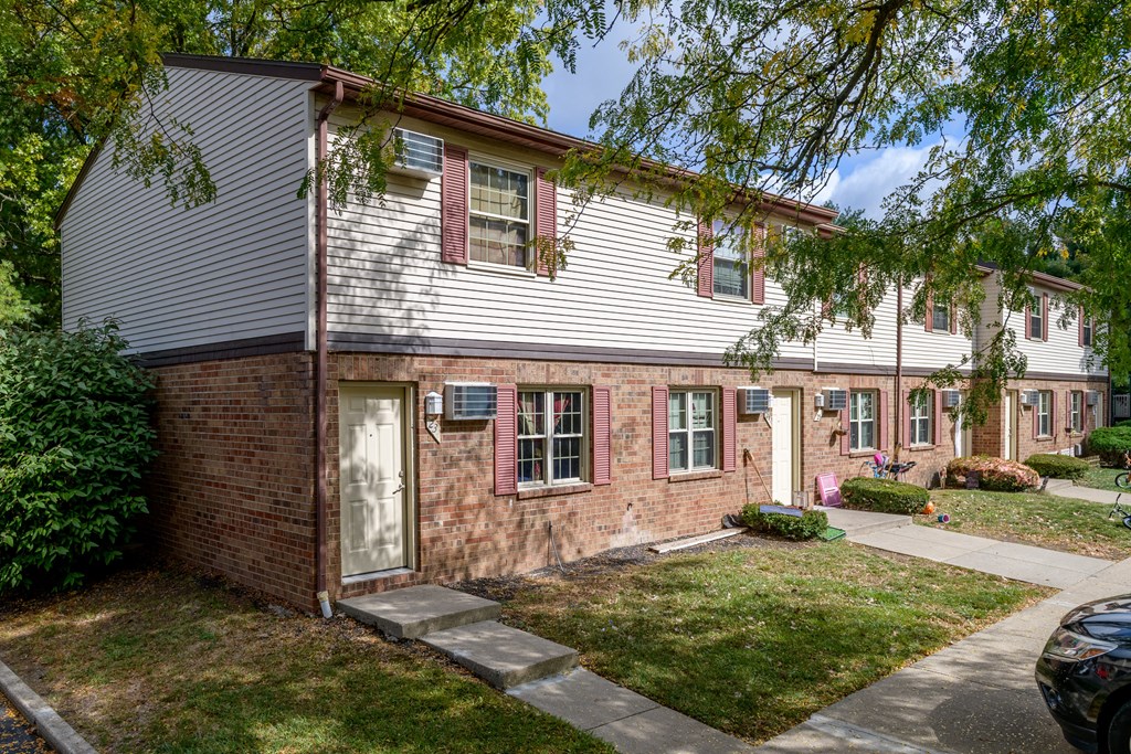 the front of a house with a yard and a tree