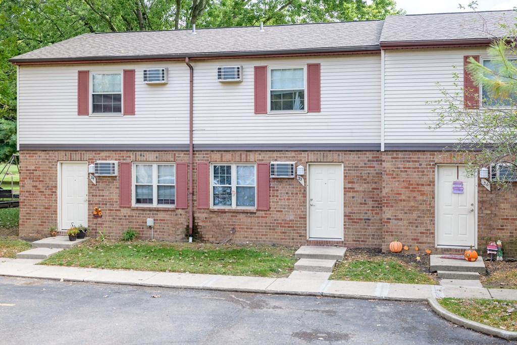 a brick and with white doors and a sidewalk