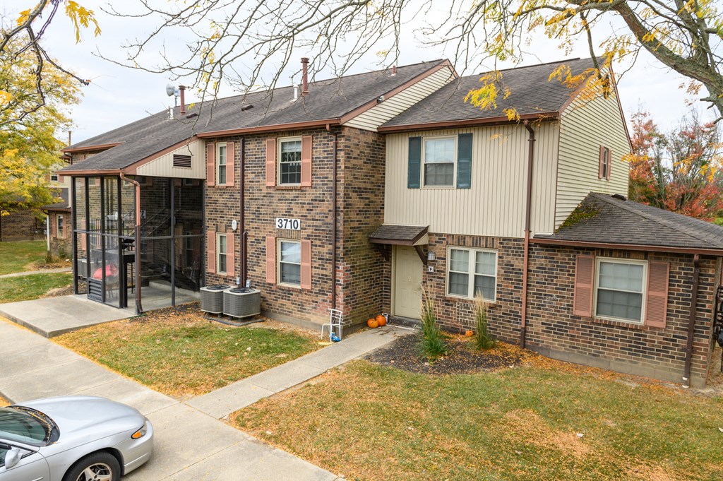 the front of a house with a sidewalk and a car parked in front of it