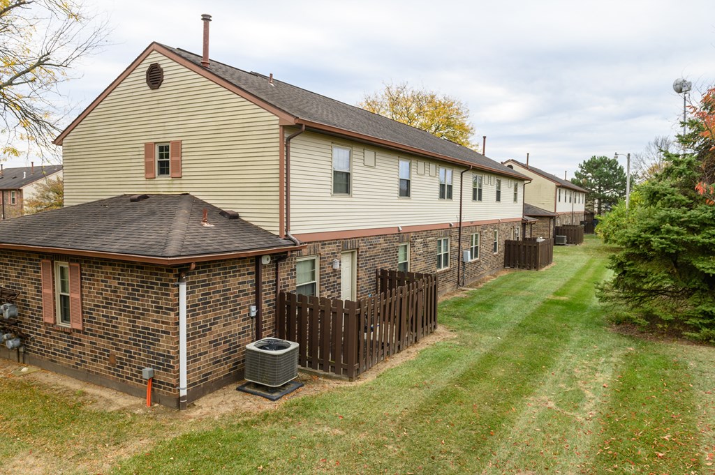 a row of houses with a yard and a fence
