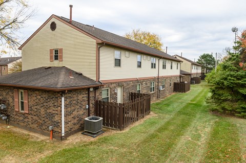 a row of houses with a yard and a fence