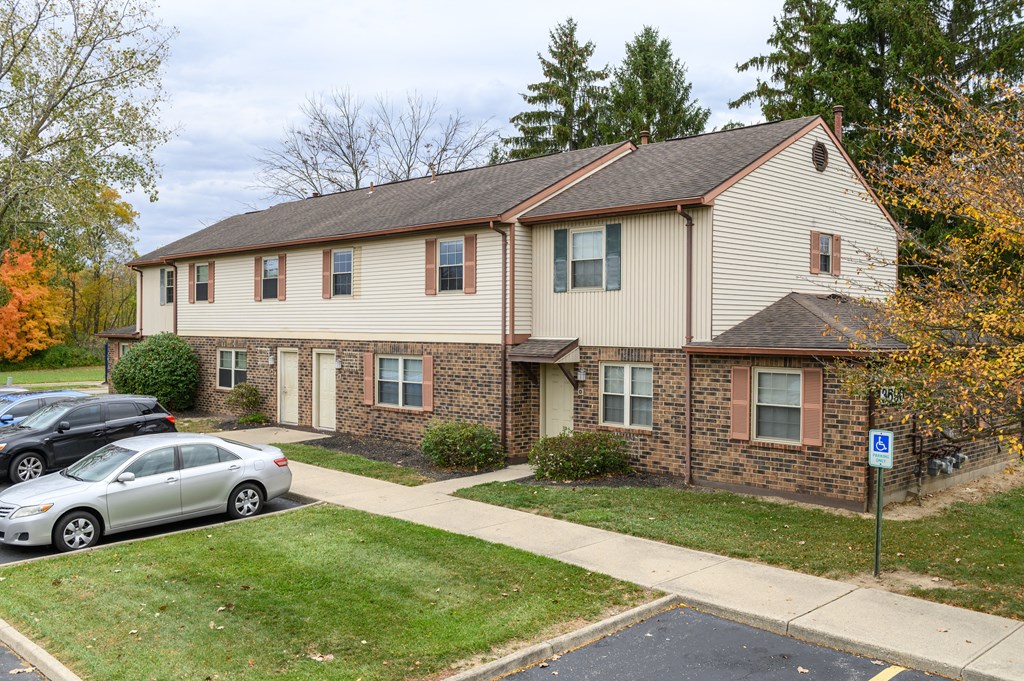 a white and brick house with a parking lot