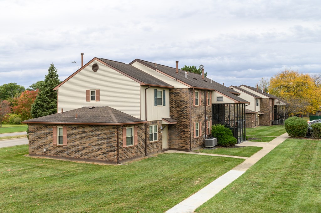 a row of houses on the side of a sidewalk