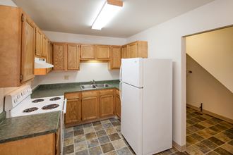 a kitchen with wood cabinets and a white refrigerator
