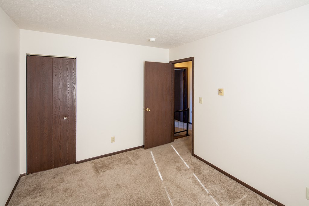 a room with a carpeted floor and a door to a hallway