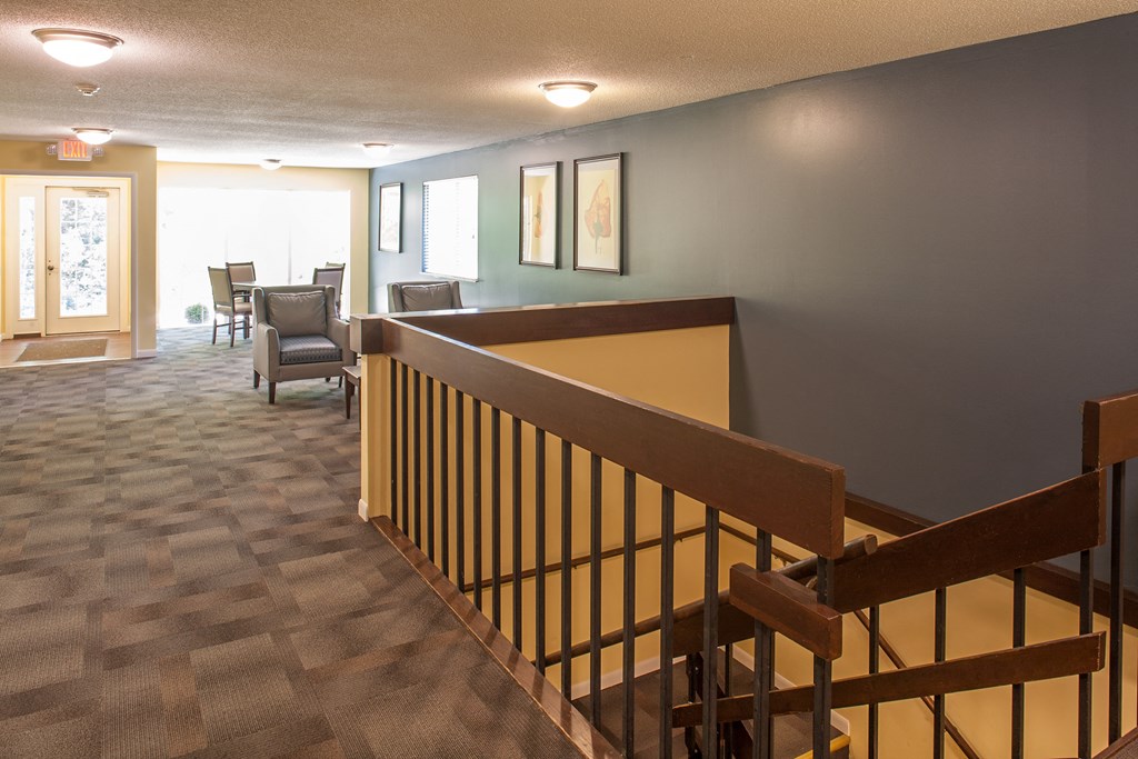 the view from the top of the stairs looking into the living room and dining room