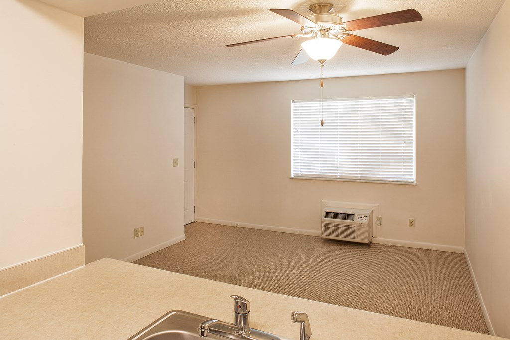 an empty kitchen with a sink and a ceiling fan