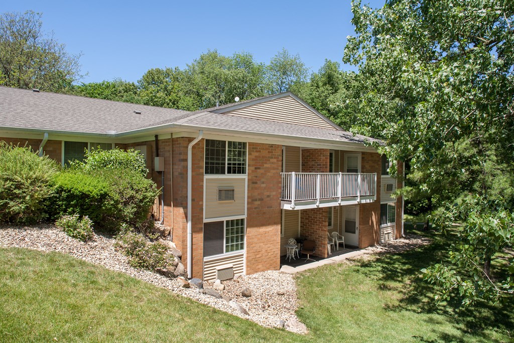 a house with a porch and a lawn and trees