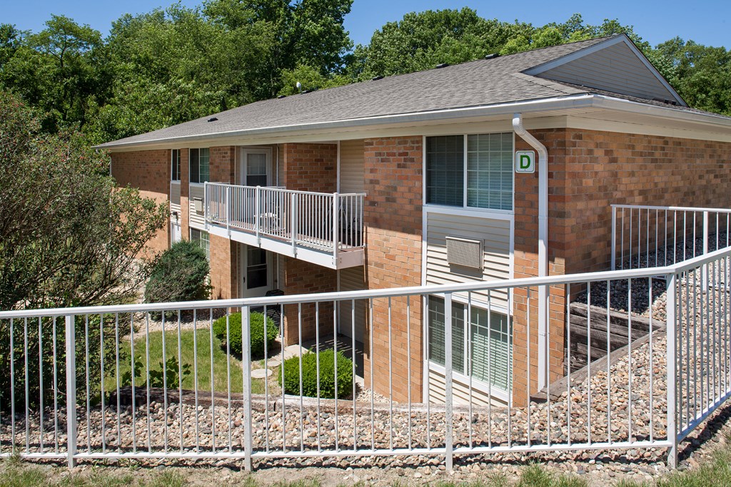 an apartment building with a white fence in front of it