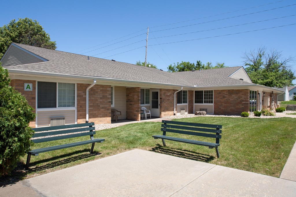 two park benches in front of a building
