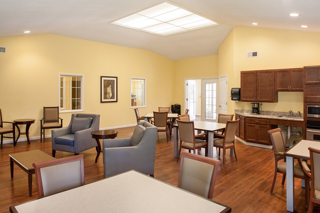a dining room with tables and chairs and a kitchen
