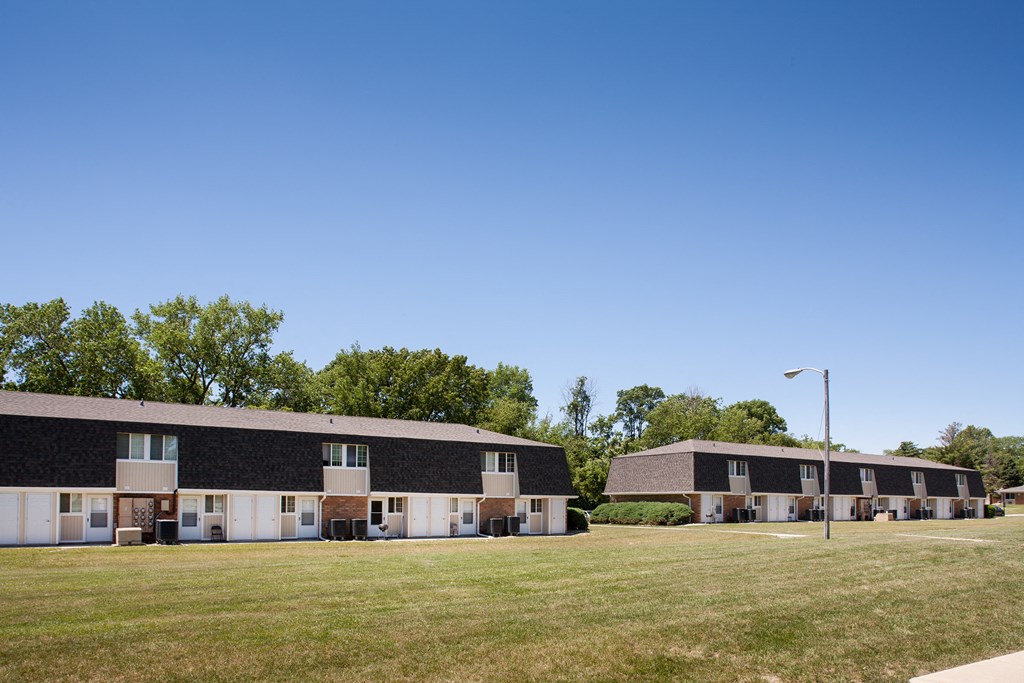 a row of houses in a field with a blue sky