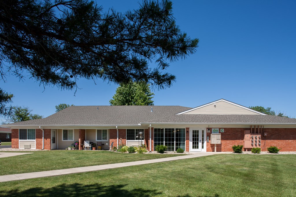 a house with a lawn and a tree in front of it