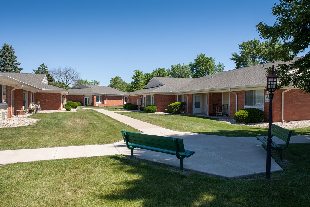 a park bench in front of a row of houses