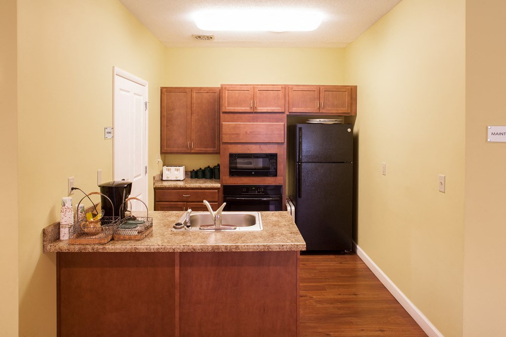 a kitchen with a granite counter top and a black refrigerator