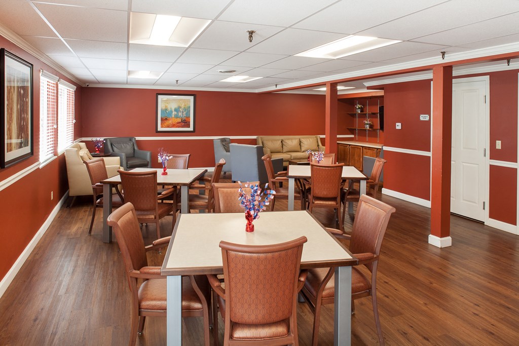a dining room with tables and chairs and a living room with couches