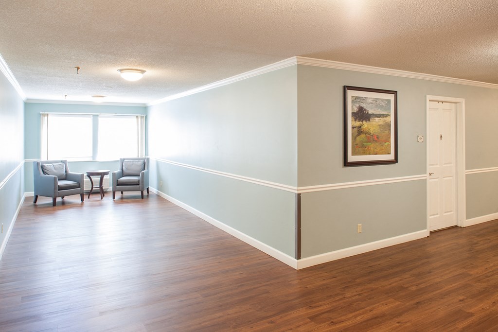 an empty living room with blue walls and a wood floor