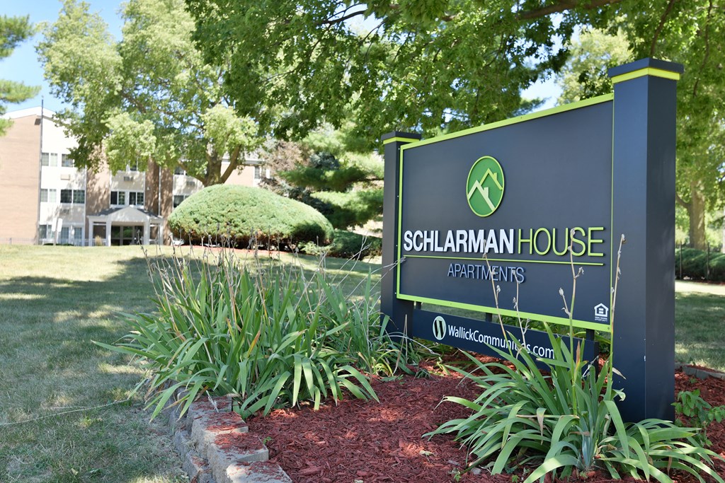 a sign in front of a lawn and trees