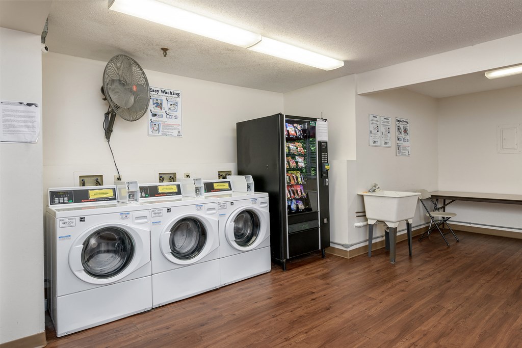 a washer and dryer in a laundry room with a sink and a refrigerator