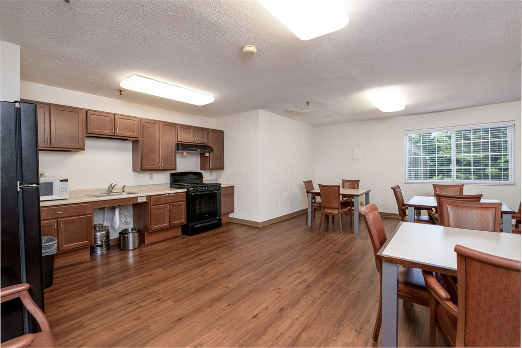 a kitchen and dining room with wood flooring and a table and chairs