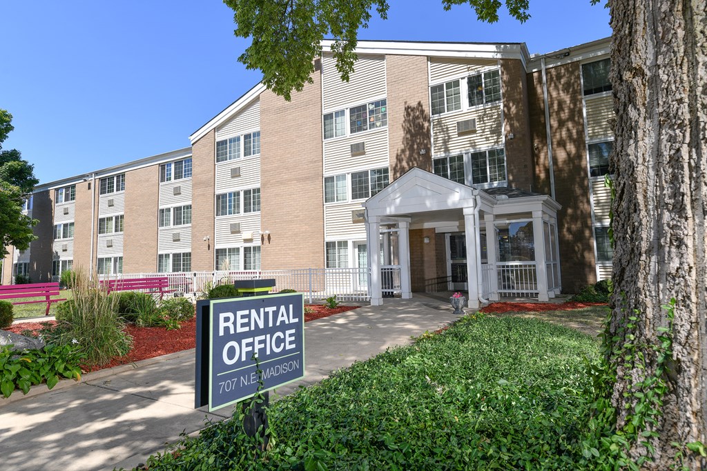 an apartment building with a rental office sign in front