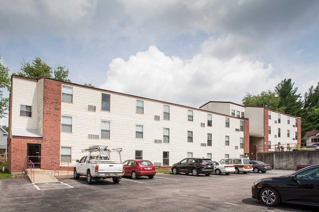 a large white building with cars in a parking lot