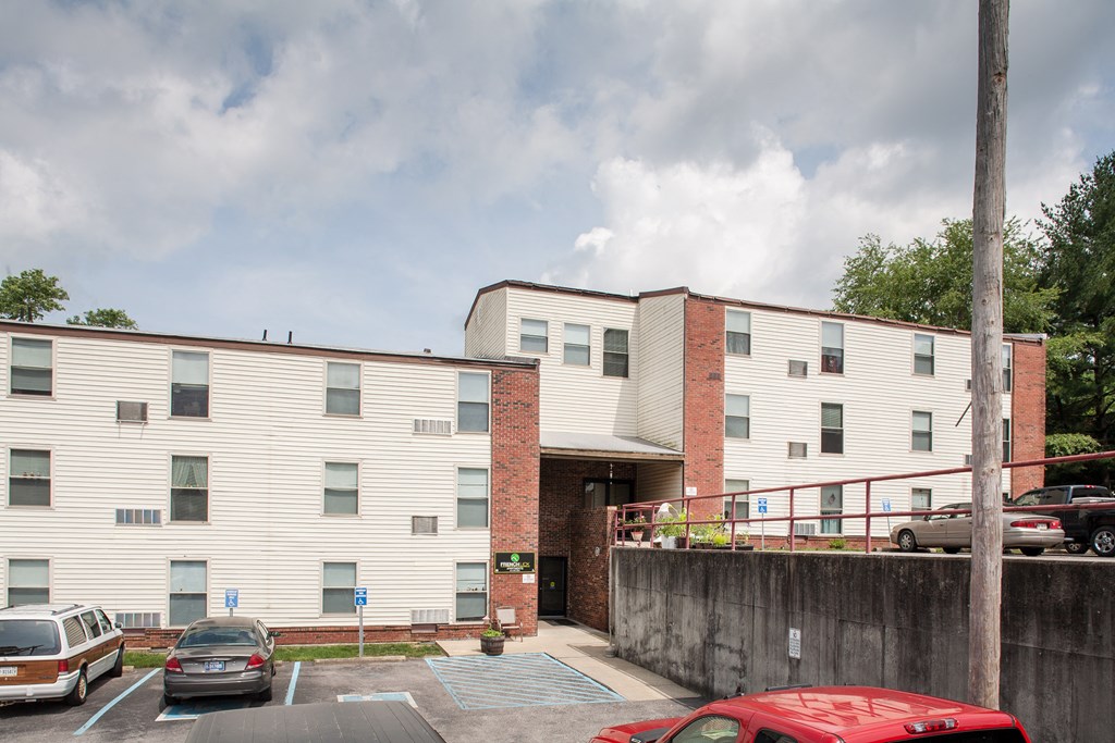the exterior of a building with cars parked in a parking lot