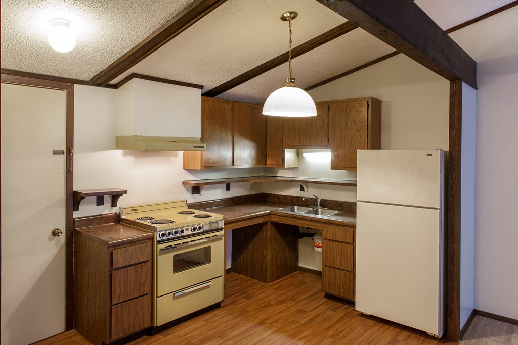 a kitchen with wooden cabinets and a white refrigerator