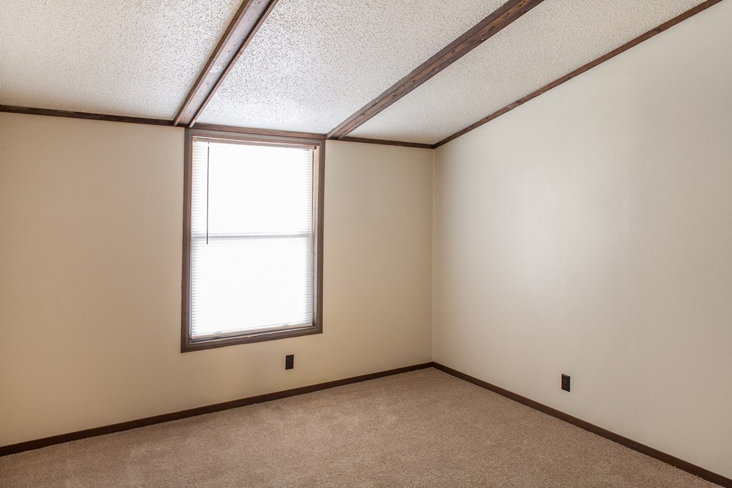 an empty room with a window and a carpet