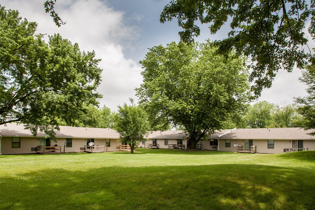 a row of houses with trees in the grass