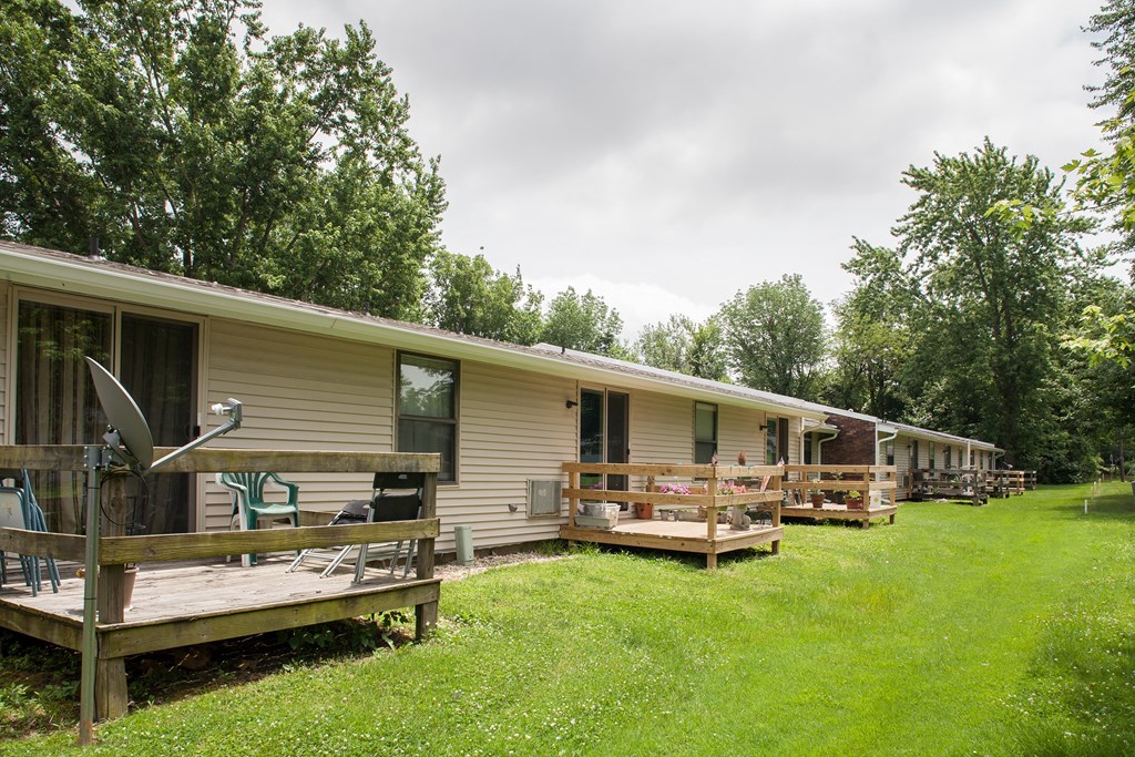 a row of mobile homes in a field with trees