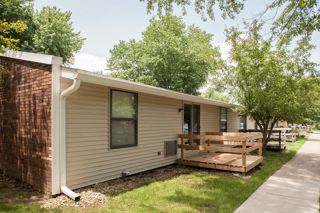 the exterior of a mobile home with a deck and trees