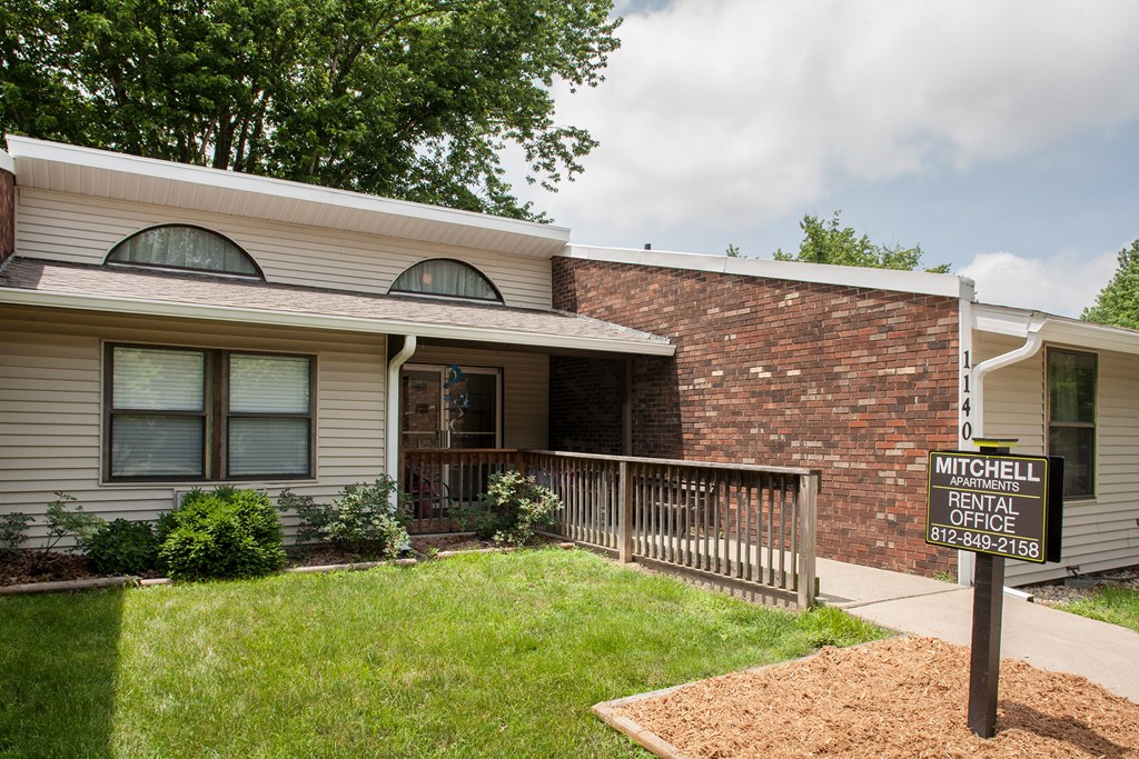 a house with a yard and a sign in front of it