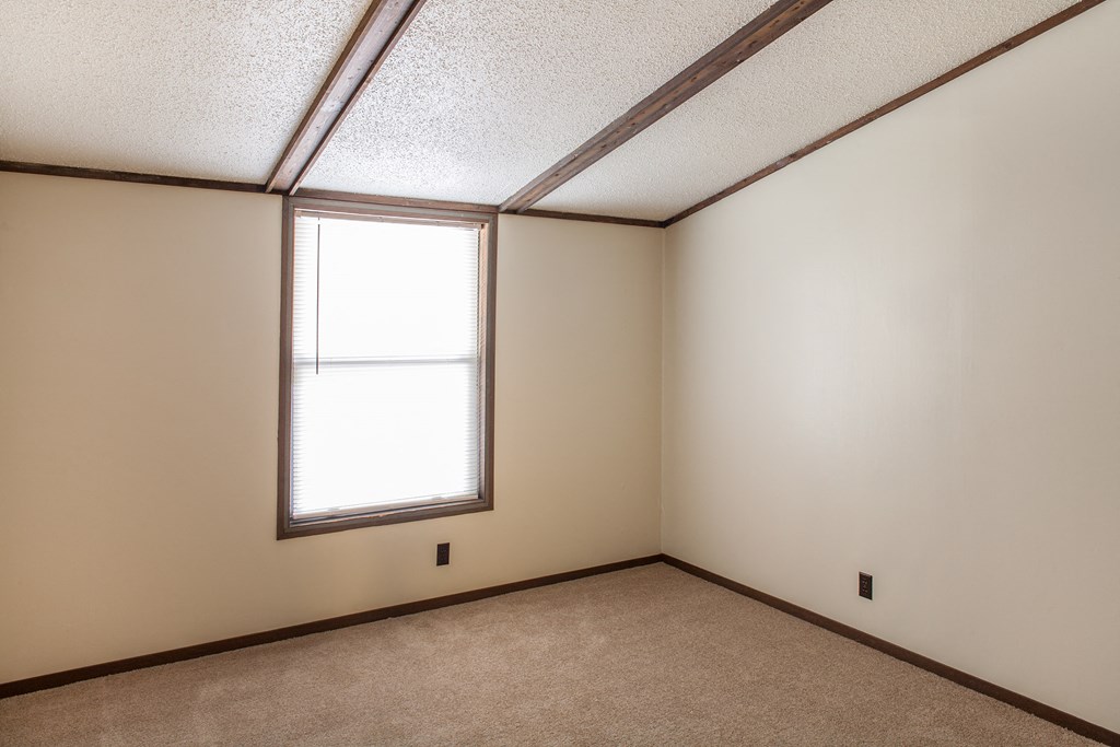 an empty room with a window and a carpet