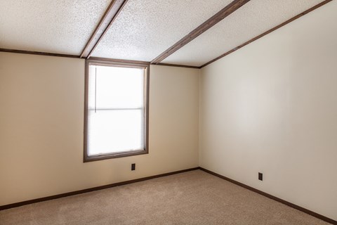 an empty room with a window and a carpet