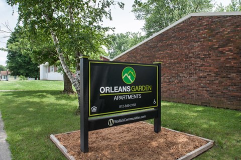 a sign apartments in front of a brick building