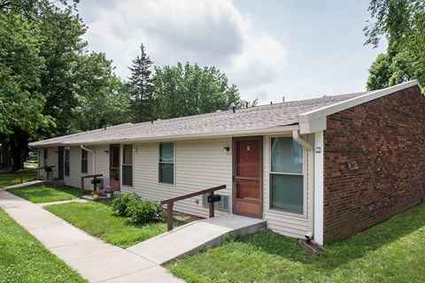 a small white house with a porch and a sidewalk