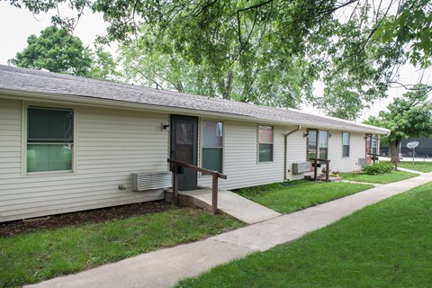 a white house with a porch and a sidewalk