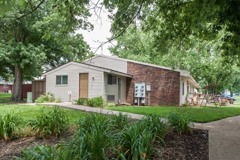 the exterior of a white house with a sidewalk and grass