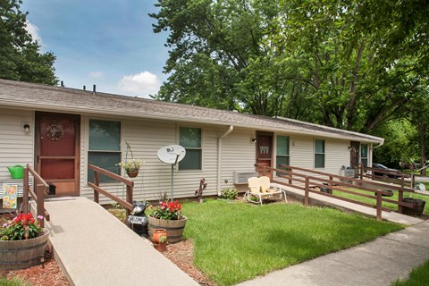a small white house with a porch and a lawn