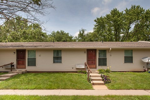a white house with a porch and a grass yard