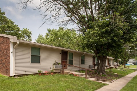 a small white house with a tree in front of it