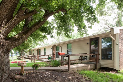 a house with a deck and a tree in front of it