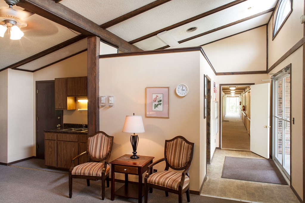 a living room with two chairs and a table and a hallway