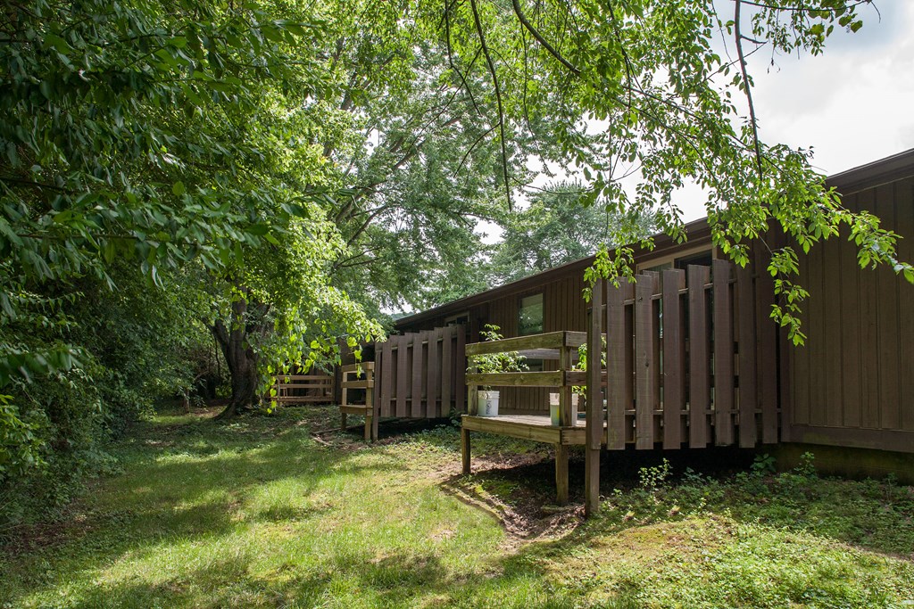 a backyard with a wooden deck and a cabin