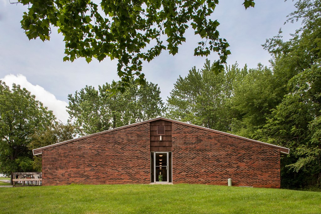 the brick building is surrounded by grass and trees